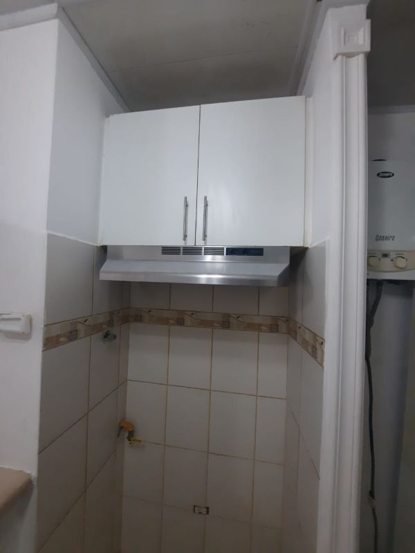 Kitchen corner with white cabinets, range hood, tile backsplash at PH Roca Park Panama