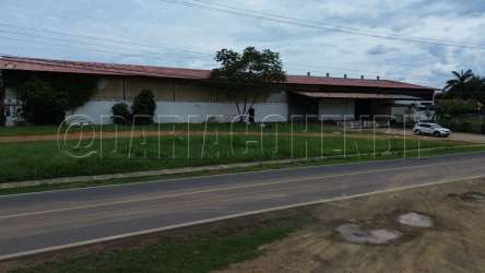 Large industrial warehouse exterior with cargo bays and parking, located in La Villa de Los Santos Panama