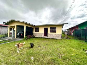Spacious living room with burgundy sofas, tiled floor, and two windows at Volcán duplex house Panama.