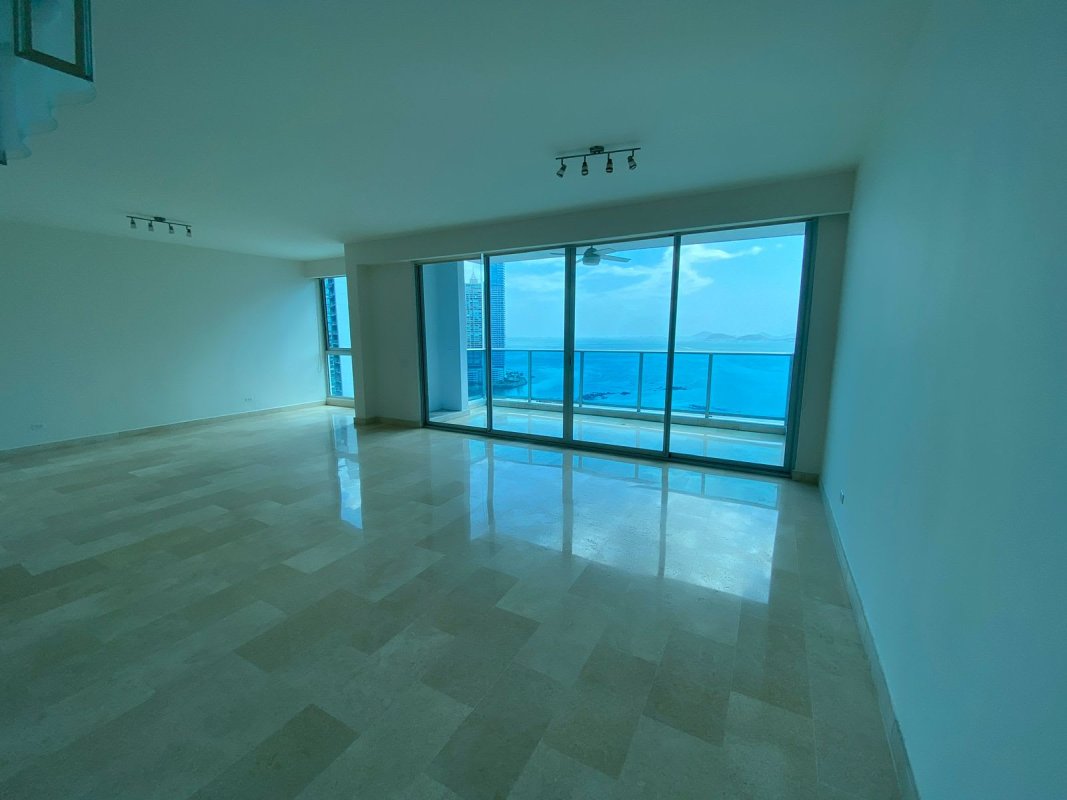 Spacious living room with ocean view floor-to-ceiling windows and balcony in PH Marabierto apartment Marbella Panama City
