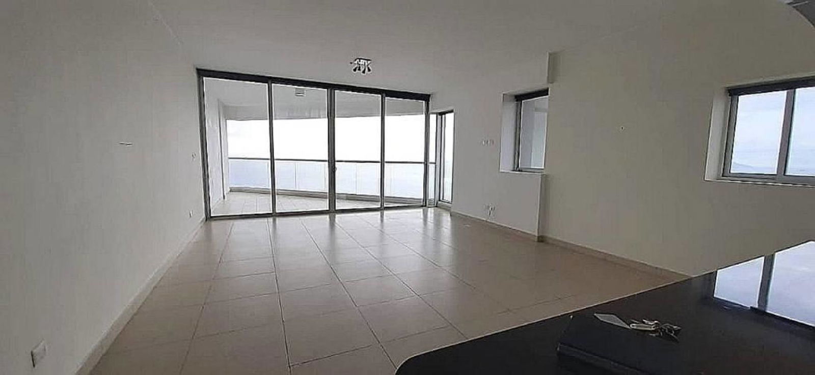 Modern living room with large windows and balcony access with ocean views at PH Rivage Panama