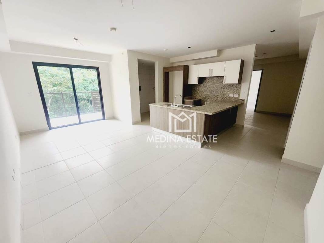 Bright living dining room with sliding glass doors to balcony at Embassy Village Clayton Panama