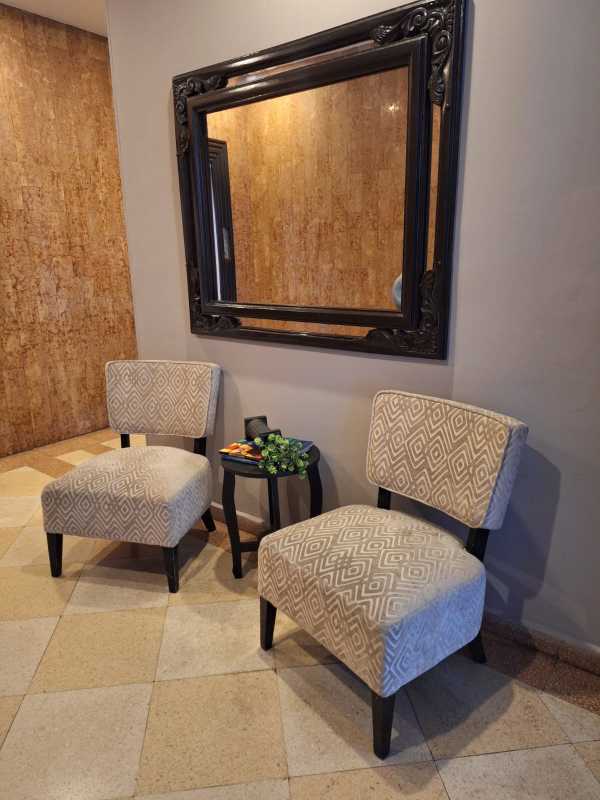 Cozy seating nook with framed mirror and chairs at entrance of apartment in PH Terrazas de Obarrio Panama City