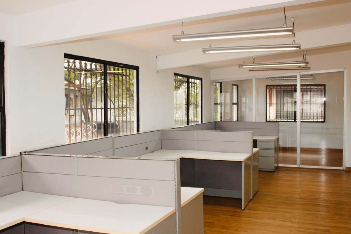 Interior office area with cubicles, large windows, wooden floors in duplex commercial Obarrio Panama