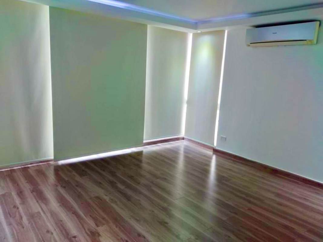 L-shaped kitchen with dark cabinets, white countertop and stainless steel hood in PH Sky Level Panama