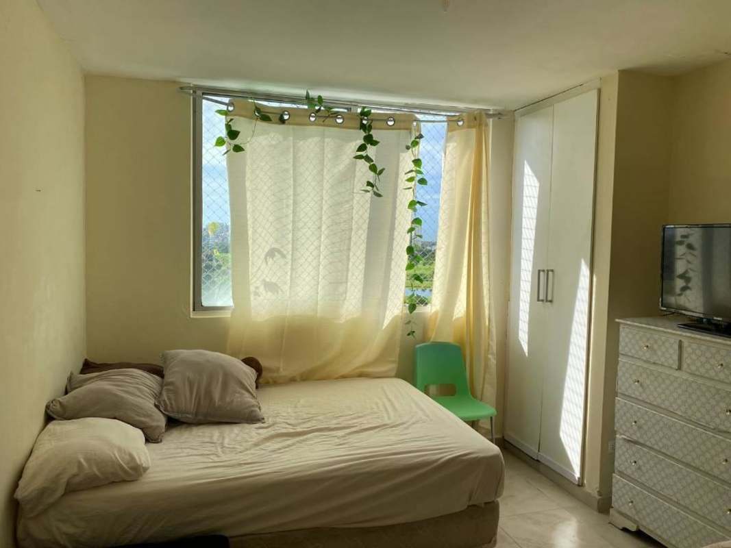 Living room with sliding doors to balcony overlooking city skyline PH Mystic Blue Juan Díaz Panama