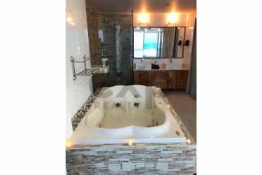 Glass railing balcony with ocean views and lounge furniture at PH Terrazas de Farallón Playa Blanca