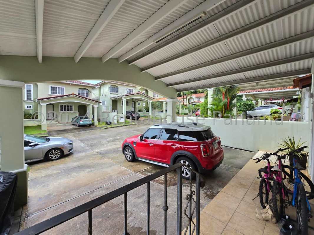 Covered carport with walkway and landscaped greenery in Villa de las Azores Villa Lucre Panama