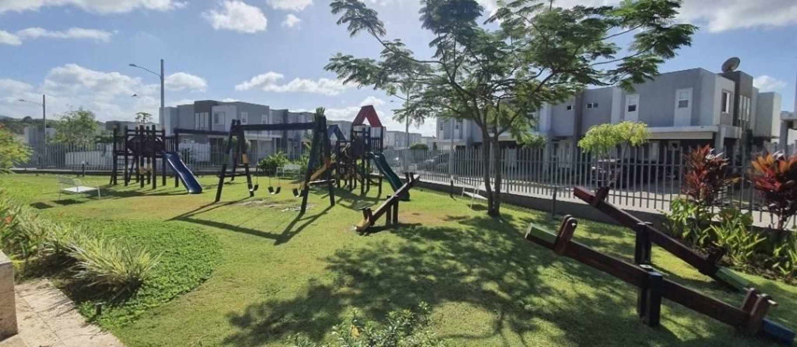 Modern residential playground with swings and green lawn at PH Augusta Victoria in Brisas del Golf