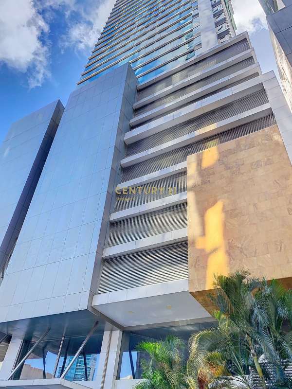 Exterior view of PH Atrium Tower with glass facade and palm trees Calle 50 Obarrio Panama