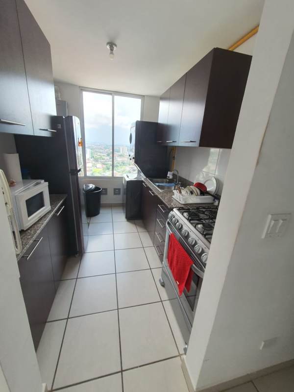 Galley kitchen granite countertops, stove, window with city view PH Lefevre 75 Panama City apartment
