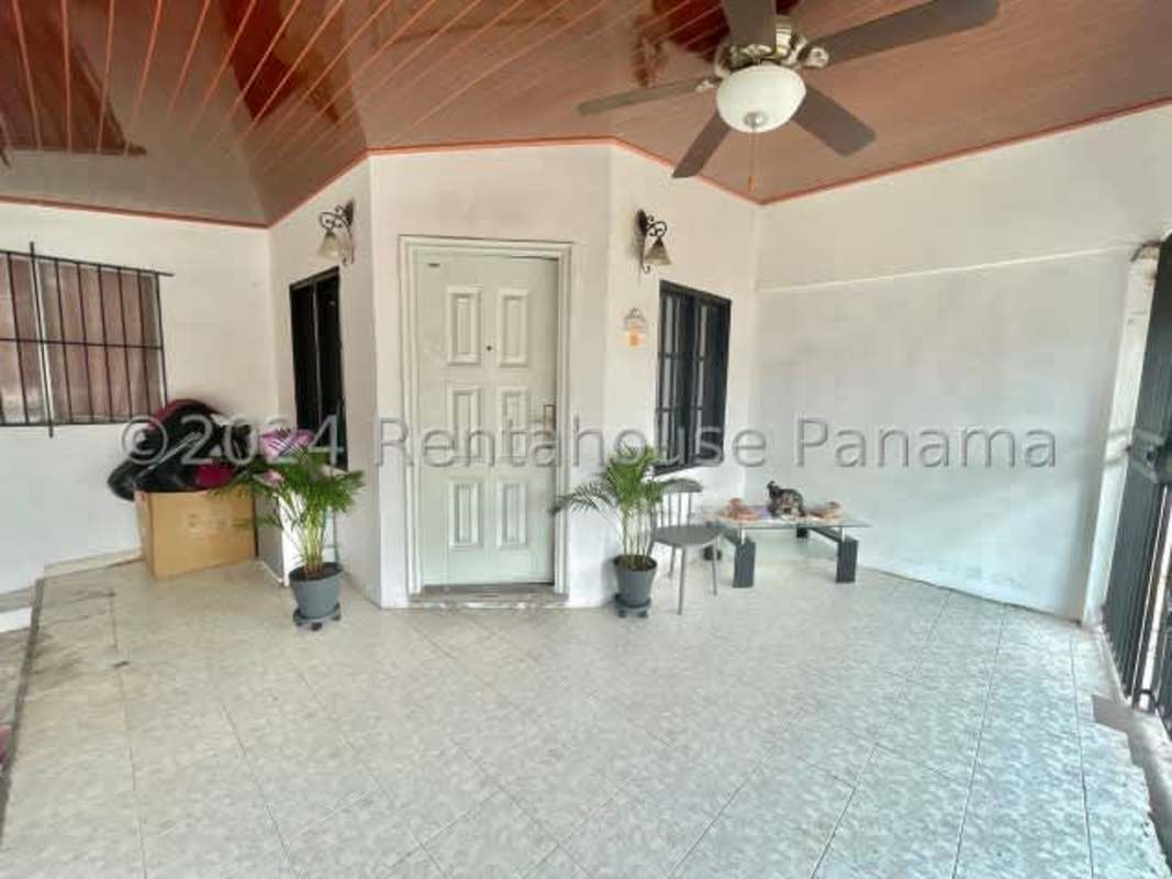 Spacious covered porch entrance with fan and security grille in Don Bosco II home
