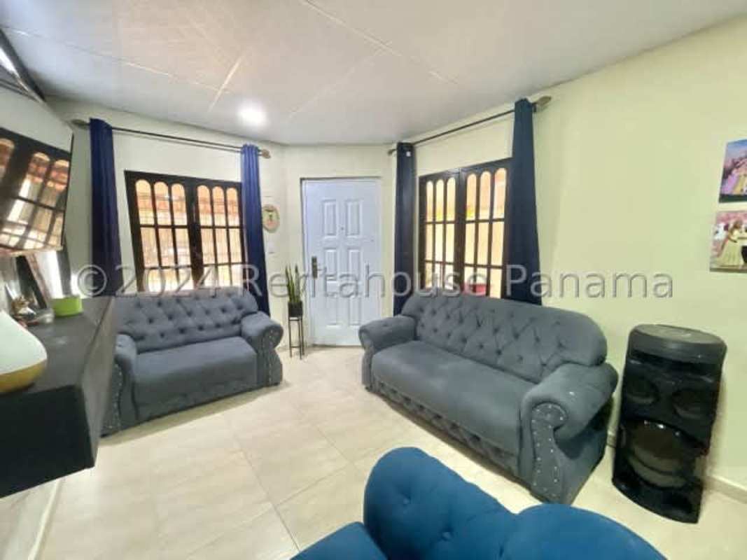 Light-filled living room with modern furniture and TV in Don Bosco II family home Panama