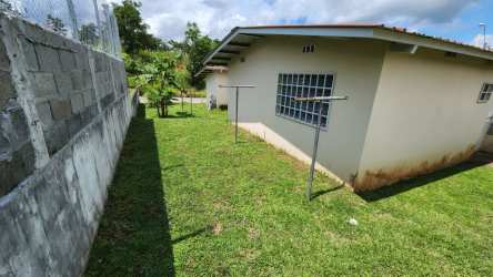 Side grassy yard and backyard area new house La Alameda II in Arraiján Panama