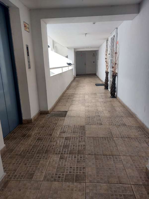 Apartment building hallway with blue elevator doors and tiled floor in PH Residencial Llano Bonito Panama