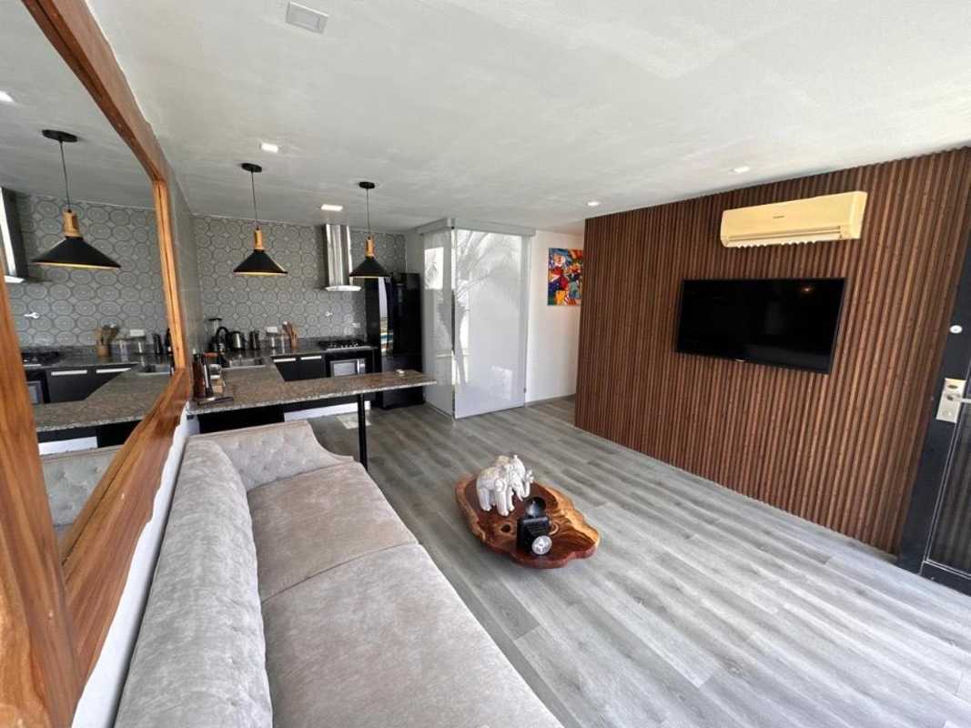 Cozy living room with wood accent wall and pool access at Bijao Resort Panama