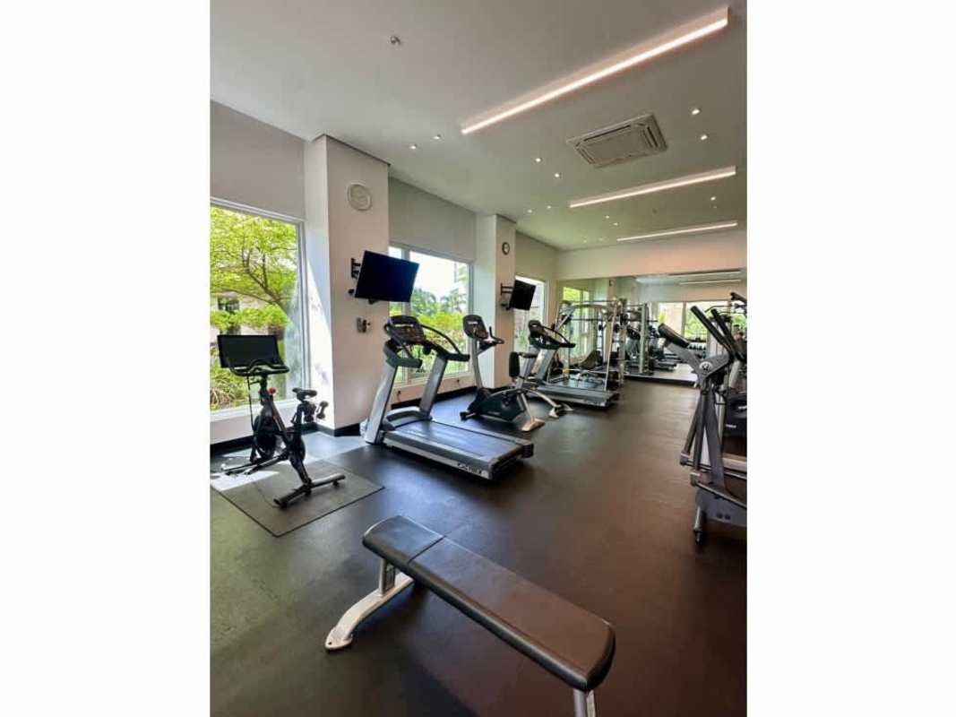 Infinity swimming pool with lake and palm trees Santa Maria Golf Panama apartment complex