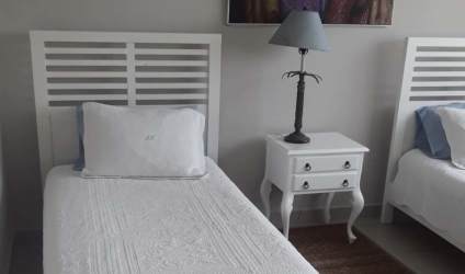 Guest bedroom with twin beds and modern decor in Quarry Heights Bijao beach condo Panama