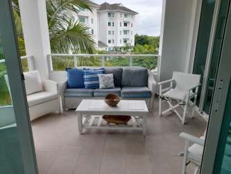 Covered terrace balcony overlooking gardens and swimming pool in Bijao Quarry Heights condo Panama