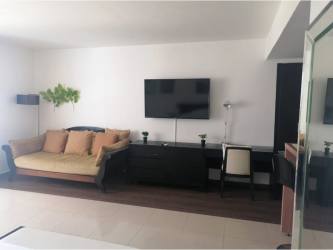 Contemporary kitchen with black granite counter, wood cabinets in Playa Blanca Beach condo Panama