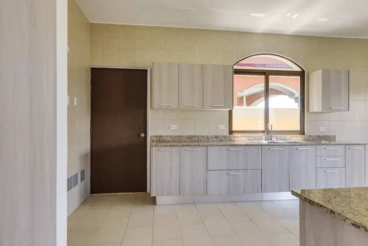 Modern hallway with staircase featuring decorative iron railing and tiled floors in El Doral Costa Sur house Panama City