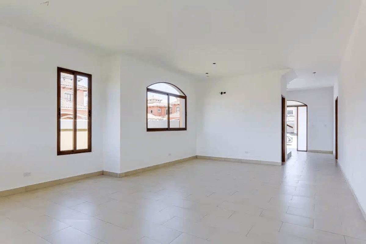 Empty living room with white walls, beige tile floor and large windows in new Costa Sur Panama house