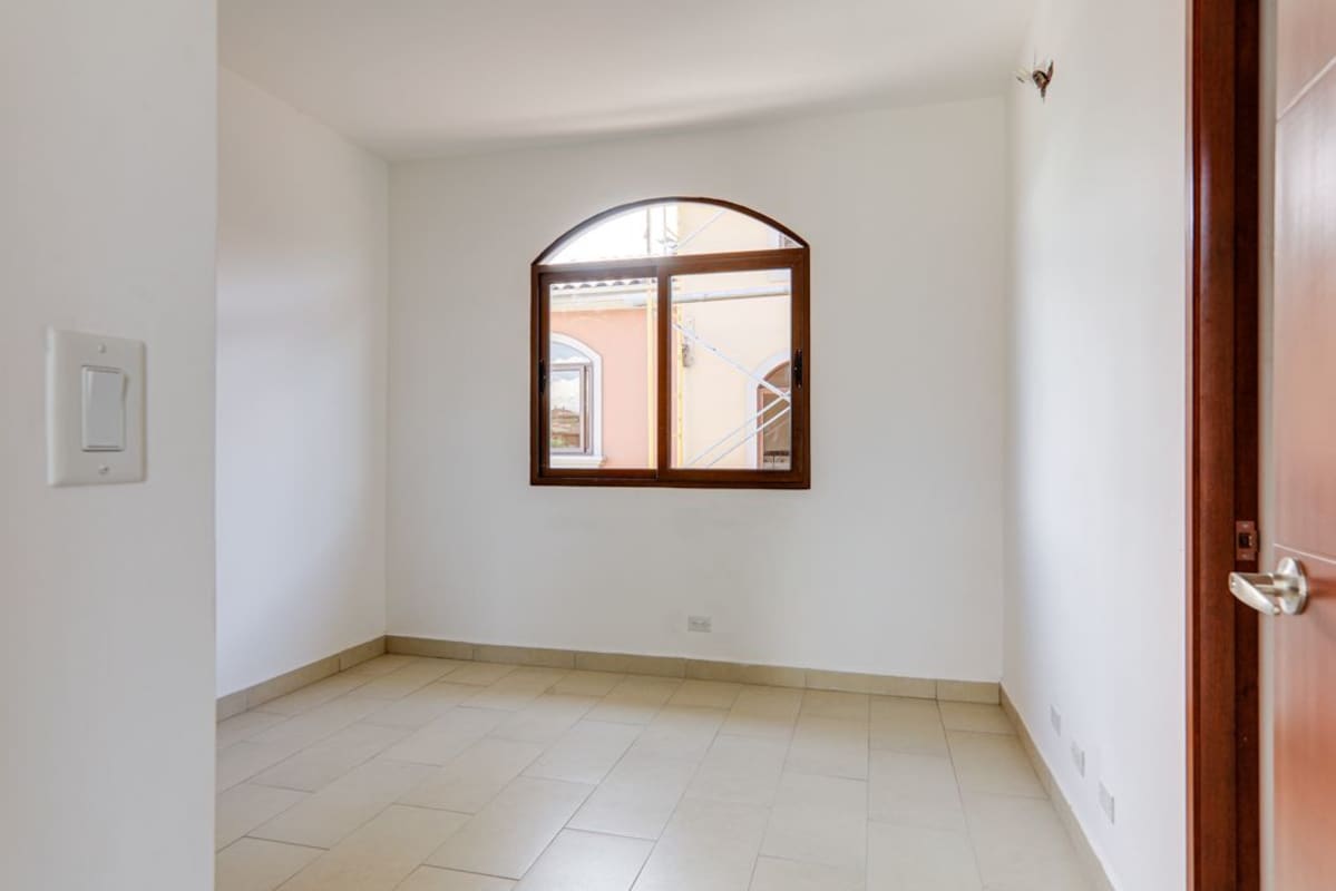 Arched window and neutral tiled floor room in Costa Sur Panama house for sale