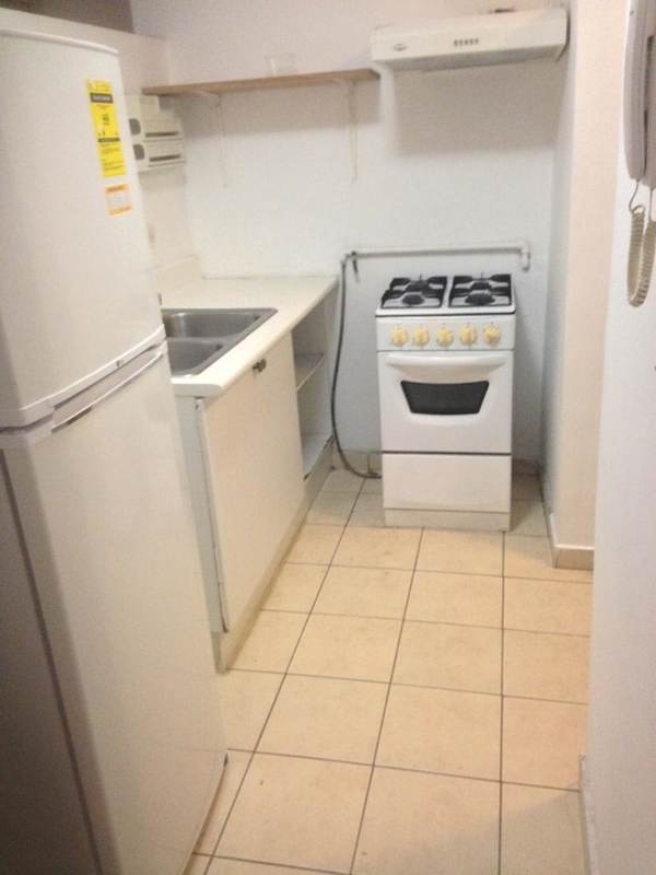 Basic kitchen with gas stove, vent hood, open shelving in PH Altos de la Colina Pueblo Nuevo Panama