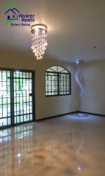 Living room space with large windows, chandelier, tiled floors in Volcán Chiriquí Panama house