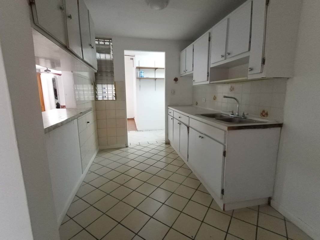 Large kitchen with white cabinetry and tile backsplash in Altos de Panamá Panama