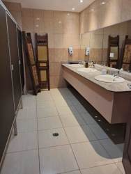 Bright restaurant dining space with wooden tables and chairs, large windows, red accent wall in Panama