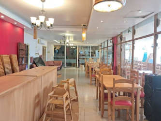 Restaurant dining hall with wood furniture, chandeliers, red wall and natural light in Playa Coronado Panama