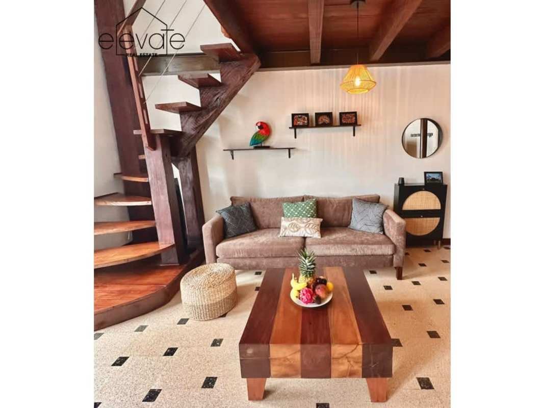 Brown sofa, wooden coffee table, spiral staircase rustic loft apartment Casco Viejo Panama