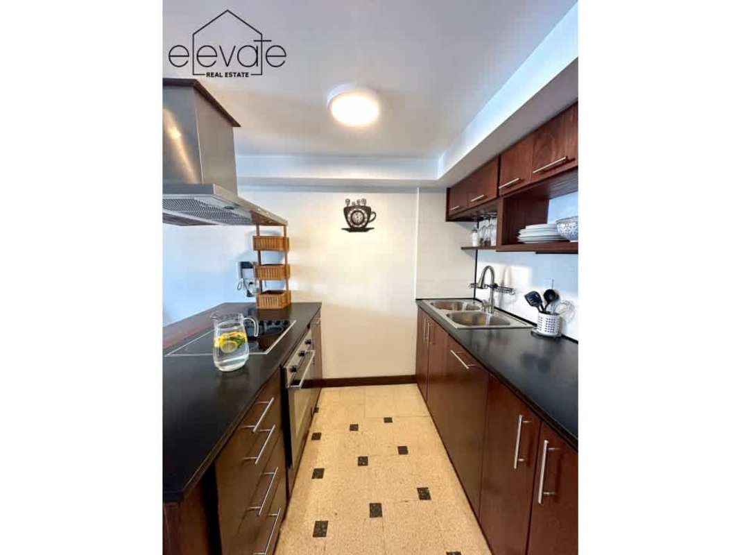 Modern kitchen with granite counters, wooden cabinets, stainless appliances Casco Viejo