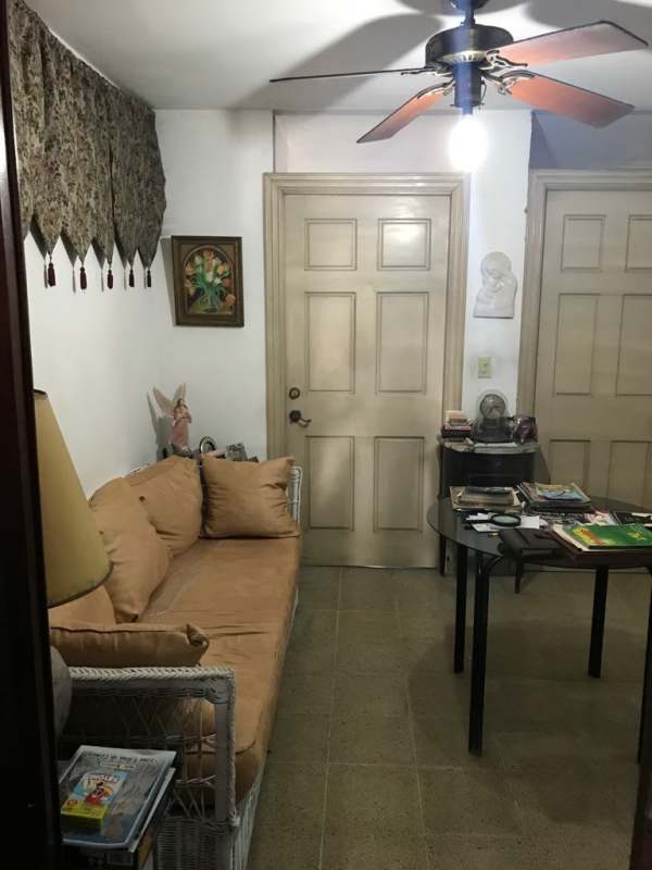 Small traditional living room with ceiling fan, tiled floor and wicker sofa PH Imperial Panama