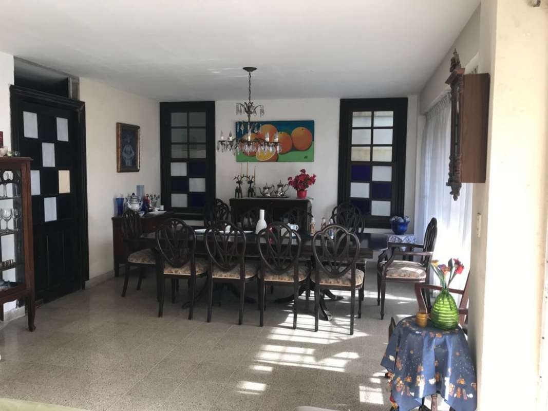 Spacious dining room with large table, chairs, chandelier and stained glass in PH Imperial El Cangrejo Panama