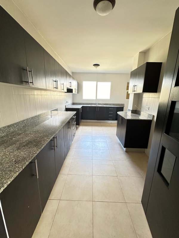 Contemporary kitchen with granite countertop, black cabinets, and large window in Villa Alta Brisas del Golf