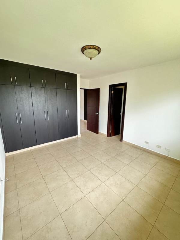 Large bedroom with built-in wardrobe and neutral tiles in Brisas del Golf villa