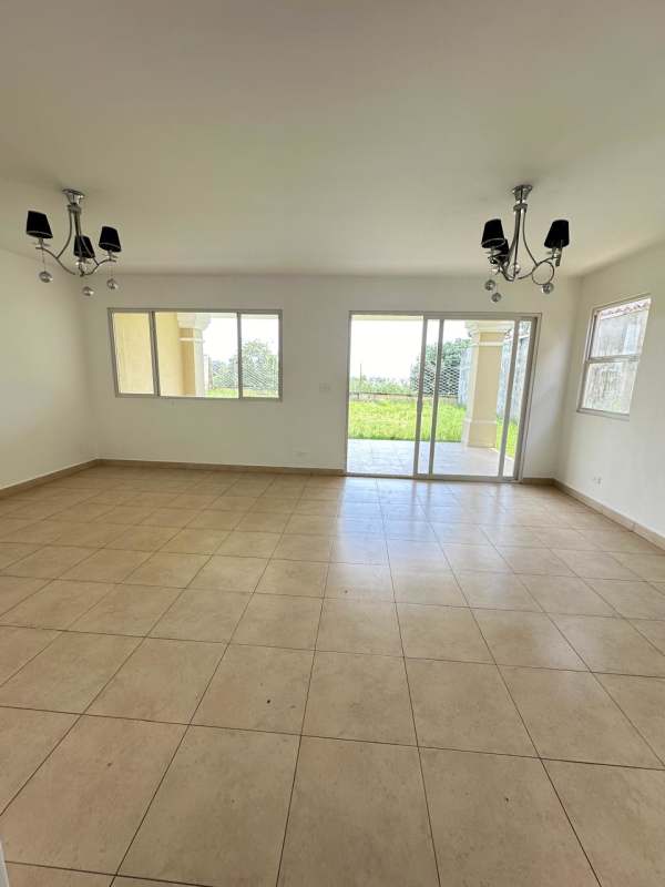 Spacious living area with tile floors, large windows and sliding doors to covered patio Villa Alta Brisas del Golf