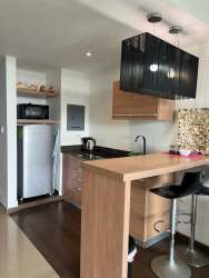 Kitchenette with granite counters and living area of furnished studio at Playa Blanca Panama Hola Realty