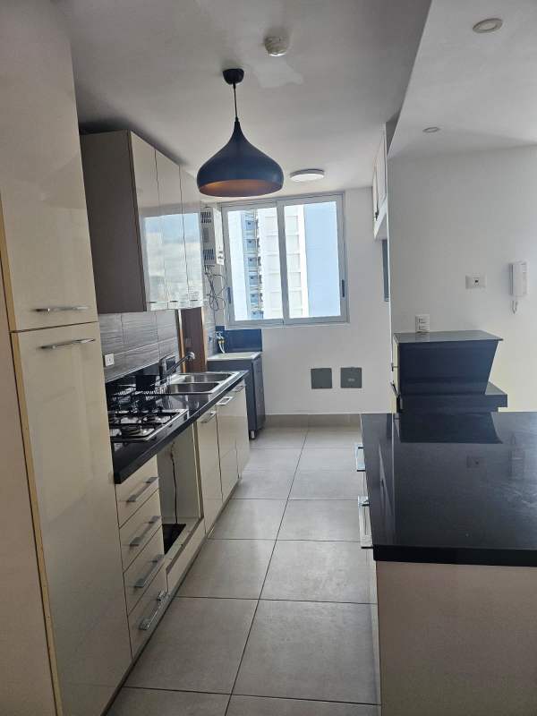 Modern kitchen with built-in cabinets, black countertop, window PH Park City Obarrio