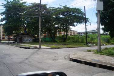 Vacant corner property with utility poles and sidewalks in Colón city Panama