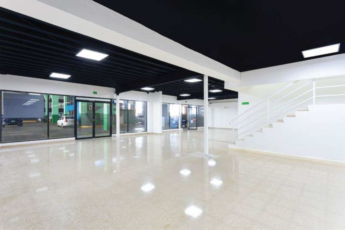 Empty commercial space with black ceiling, lighting, tile floor and mezzanine Plaza Agora Panama