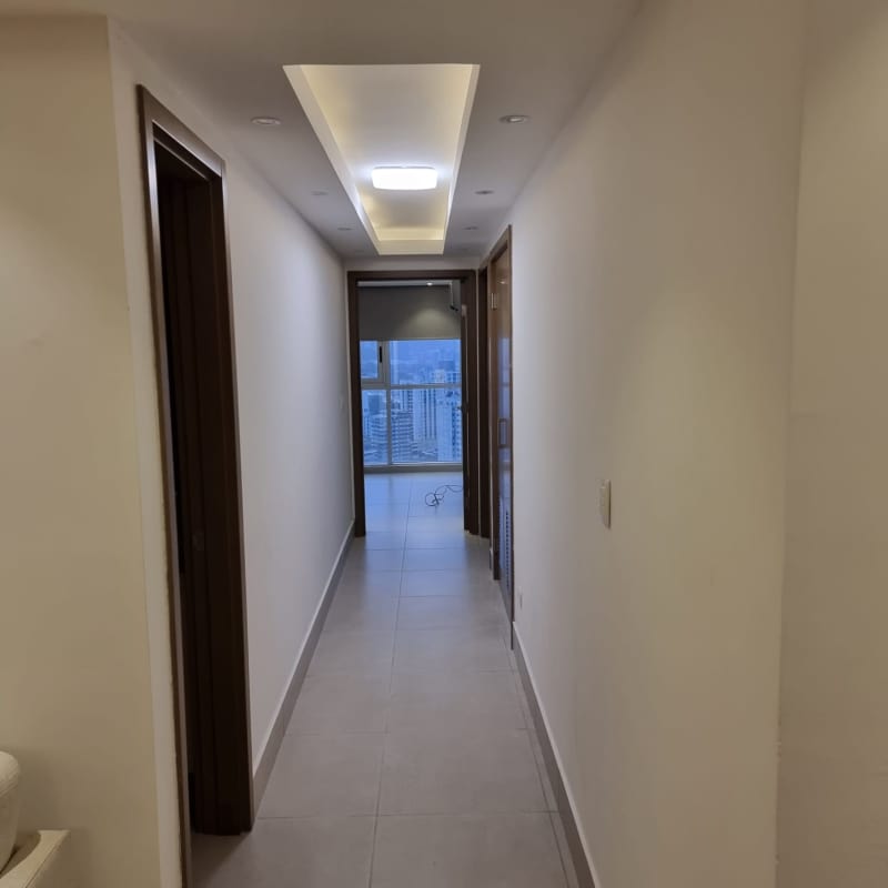 Modern bedroom with wood accent wall and skyline view in Park City Obarrio