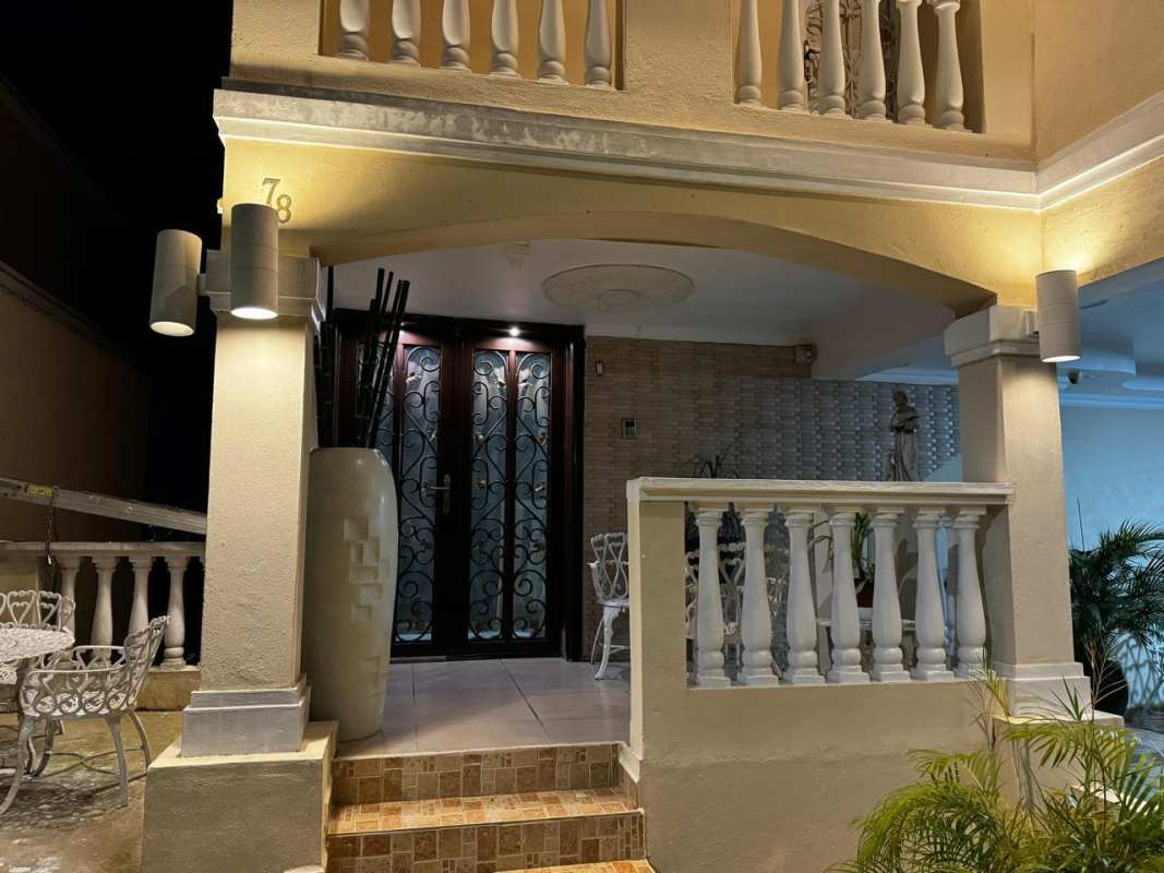 Modern dining room with large glass table, chandelier, window in private house Altos de Panamá