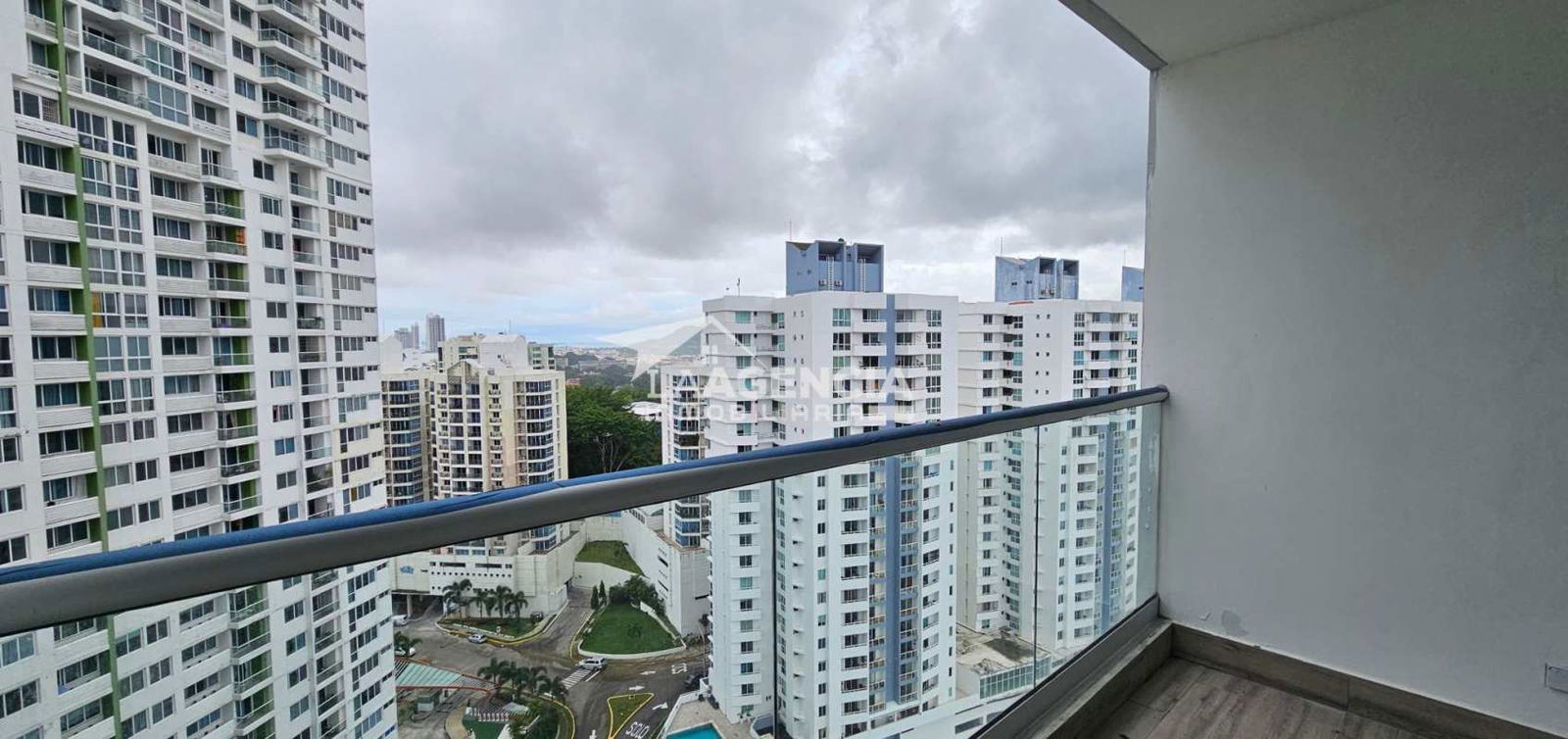 Open kitchen with light wood cabinets, double sink and pass-through in PH Vivendi Green Panama City