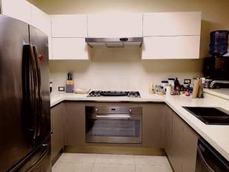 Open kitchen with granite counters and stainless appliances in PH CasaMar Panama