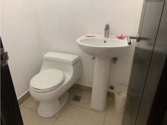 Minimalist white bathroom with pedestal sink in Panama Pacifico PH Soleo apartment