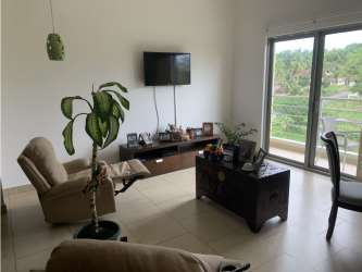 Modern living room with TV, natural light, and balcony in PH Soleo Panama Pacifico condo
