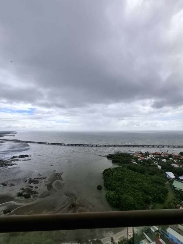 Kitchen with city view window, white cabinetry, double sink in Coco del Mar apartment